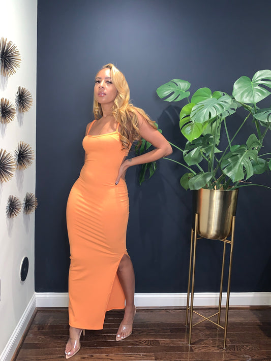 Orange ribbed maxi dress with adjustable straps and a side slit.
